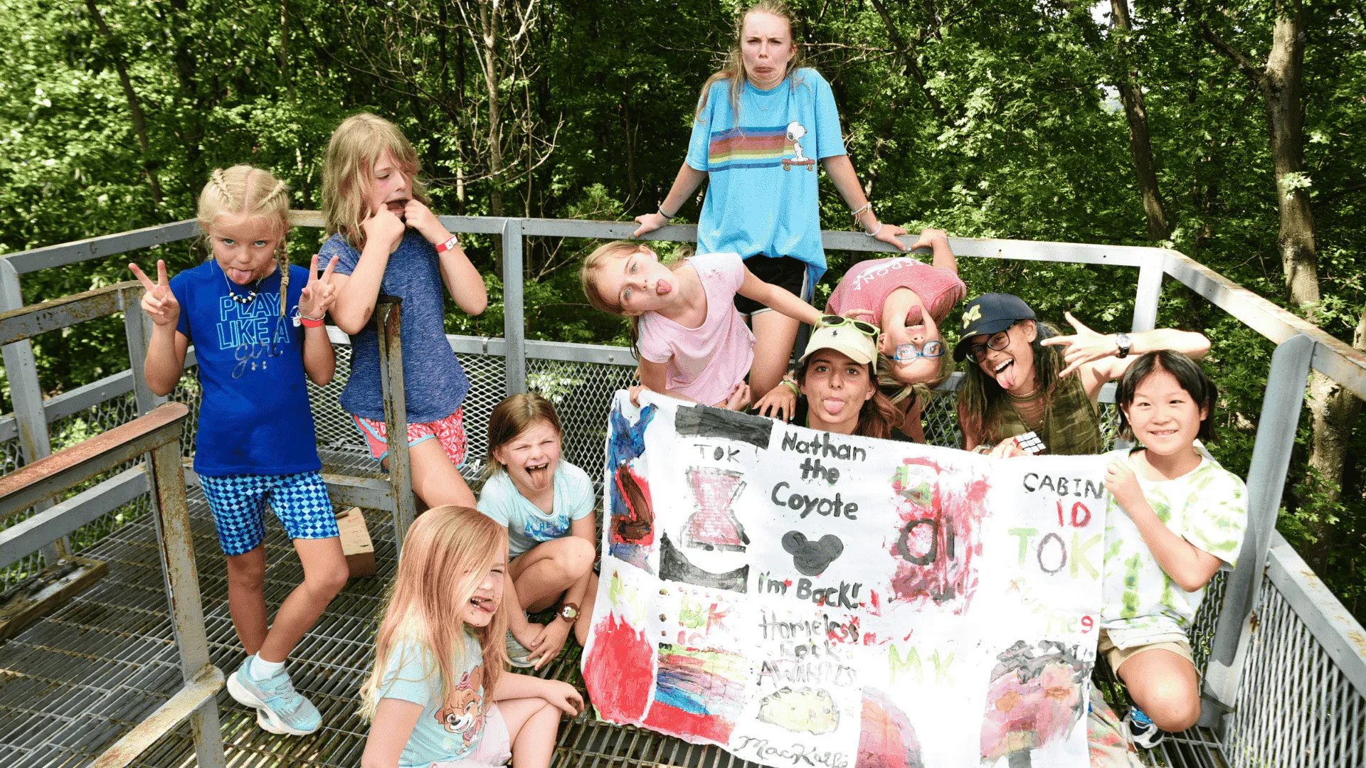 A group of kids at camp with their camp flag