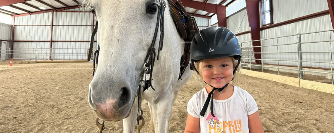 A little girl with a white horse