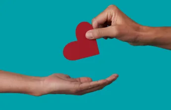 Someone handing someone a paper heart